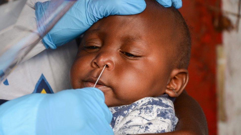 A baby in Kenya being swabbed.