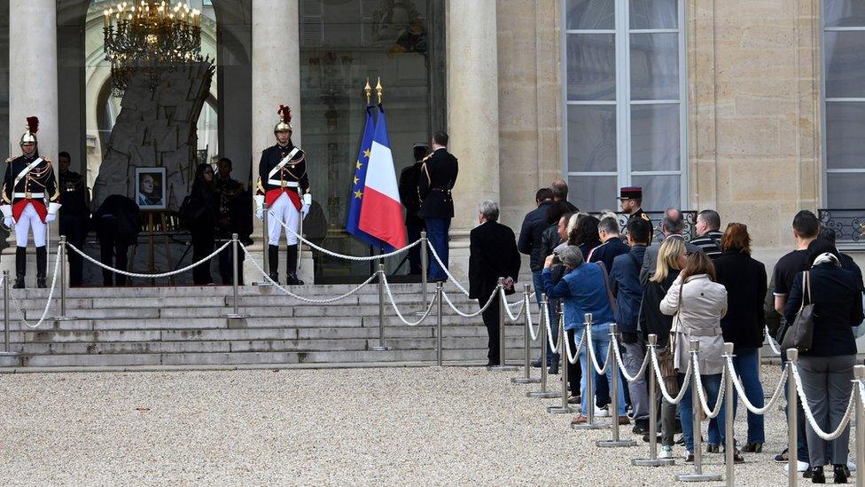 French public queue to pay tribute in front of a picture of the late French President Jacques Chirac displayed at the Elysee presidential palace