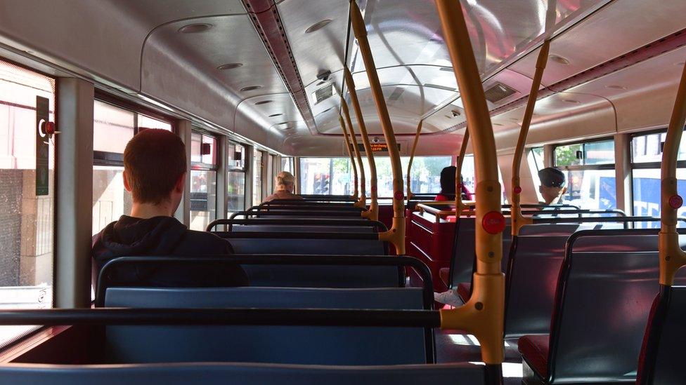 People socially distancing on a bus.