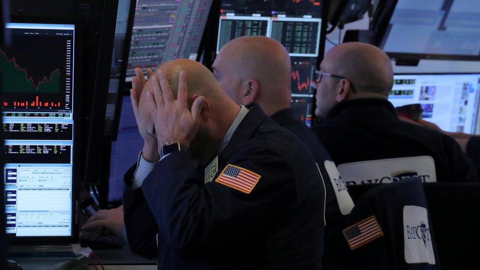 A trader works at his post on the floor of the New York Stock Exchange