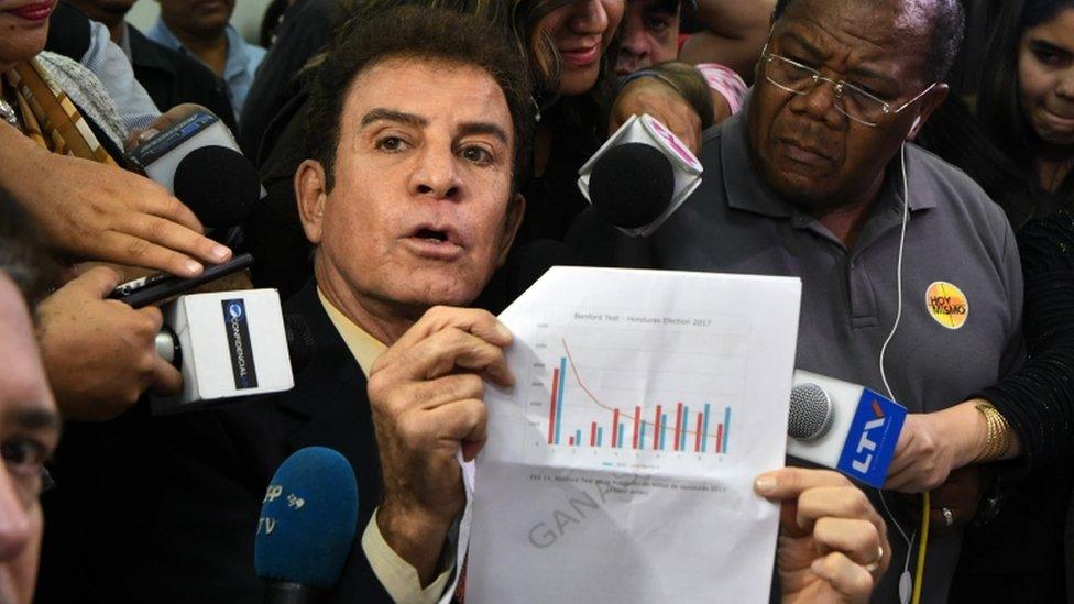 The presidential candidate for Honduras" Opposition Alliance against the Dictatorship, Salvador Nasralla (centre L), gestures as he meets with coordinator of the Electoral Supreme Tribunal, Leticia Henriquez (not pictured), to present a document asking to annul the results of the still-unresolved November 26 vote