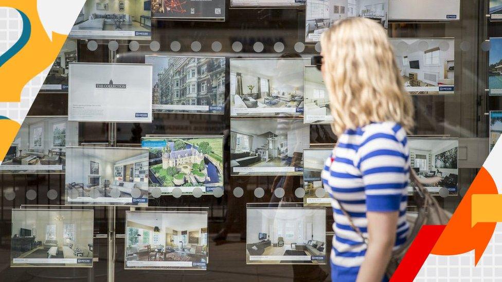 Woman looking inside an estate agent's window