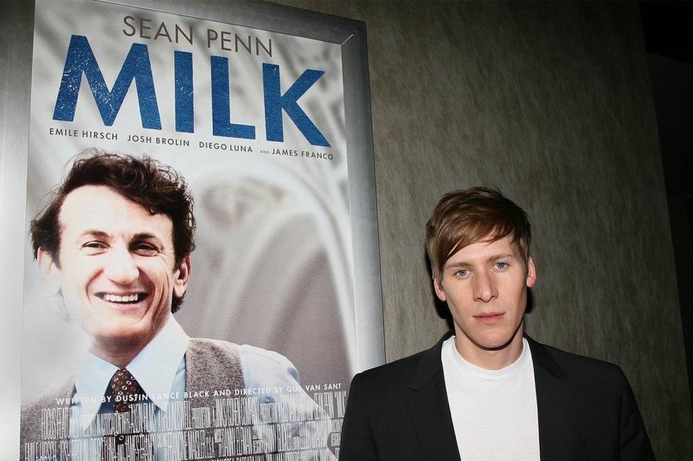 Dustin Lance Black and a poster of his Oscar-winning film