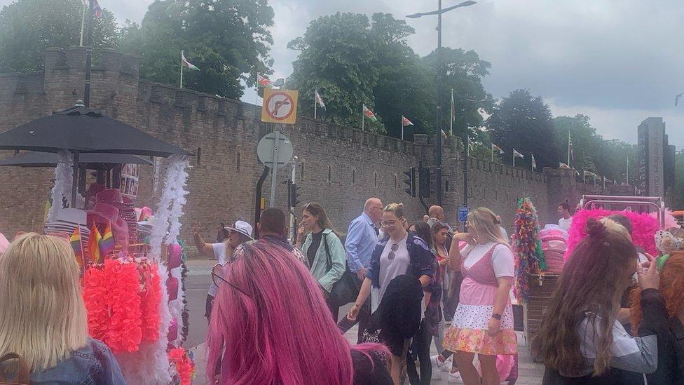 People milling around outside the castle with feather boas and pink cowboy hats