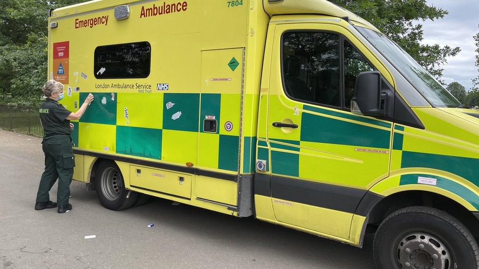 Adhesive stickers are removed from an ambulance in Hyde Park