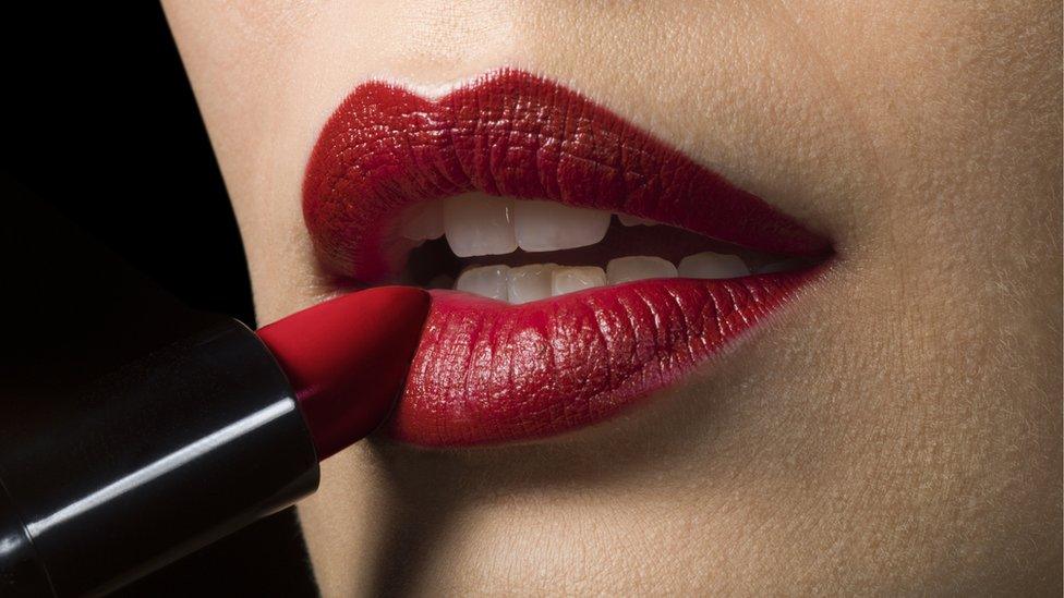 Woman applying red lipstick