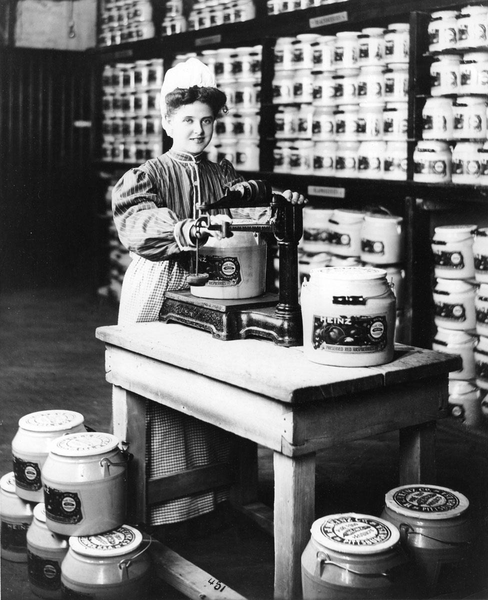 A woman weighing preserved red raspberries at the Heinz Company in 1880