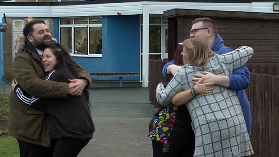 Staff and parents hug outside school