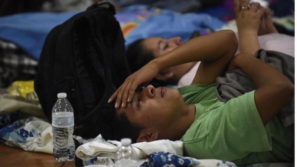 A man lies on a hard floor in a temporary shelter in Escuintla department, 35 km south of Guatemala City on June 3, 2018