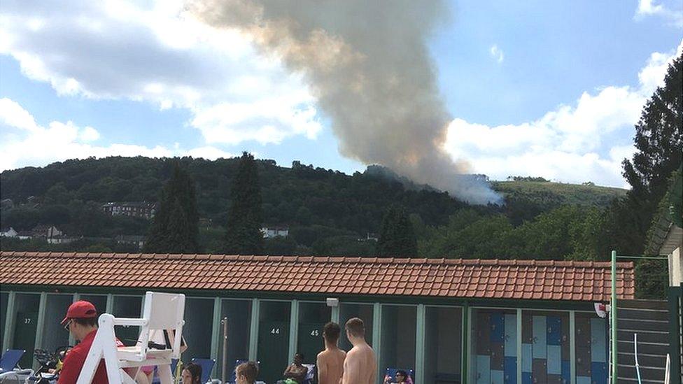 Fire in the hills above an outdoor swimming pool