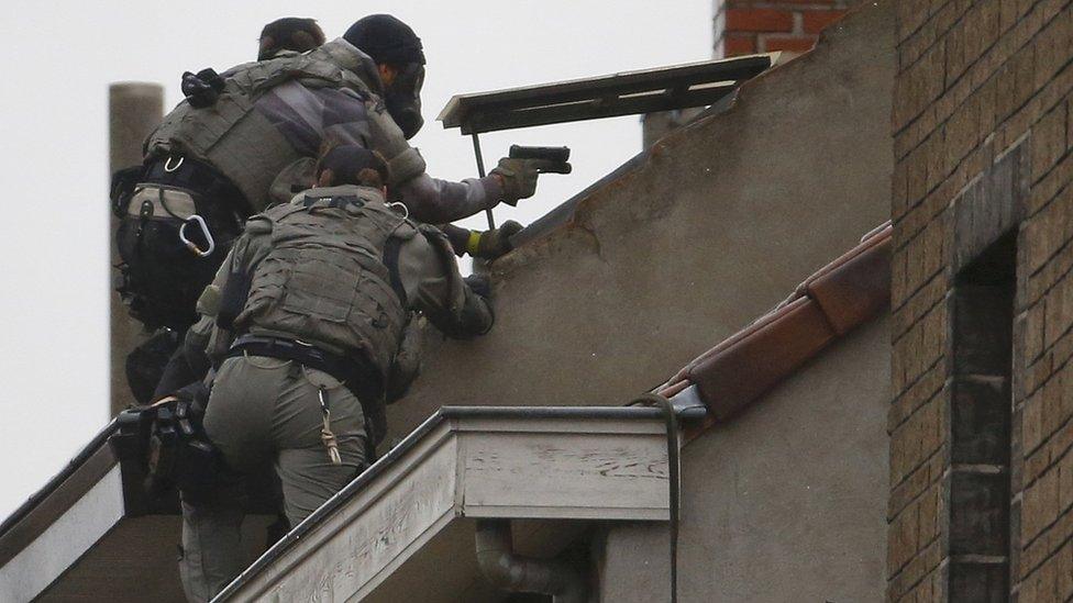 Belgian special forces police climb high on an apartment block during a raid, in search of suspected Muslim fundamentalists linked to the deadly attacks in Paris, in the Brussels suburb of Molenbeek