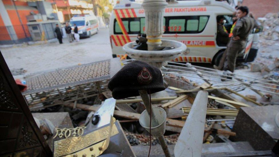 A police beret (C) among debris at the scene a day after a suicide bomb blast at a Mosque in Police Lines, in Peshawar