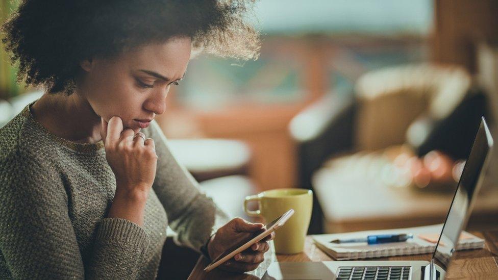 Woman looks at phone screen