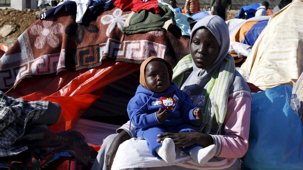 Sudanese refugees from Darfur sit near their tent outside the United Nations High Commissioner for Refugees (UNHCR) office in Amman