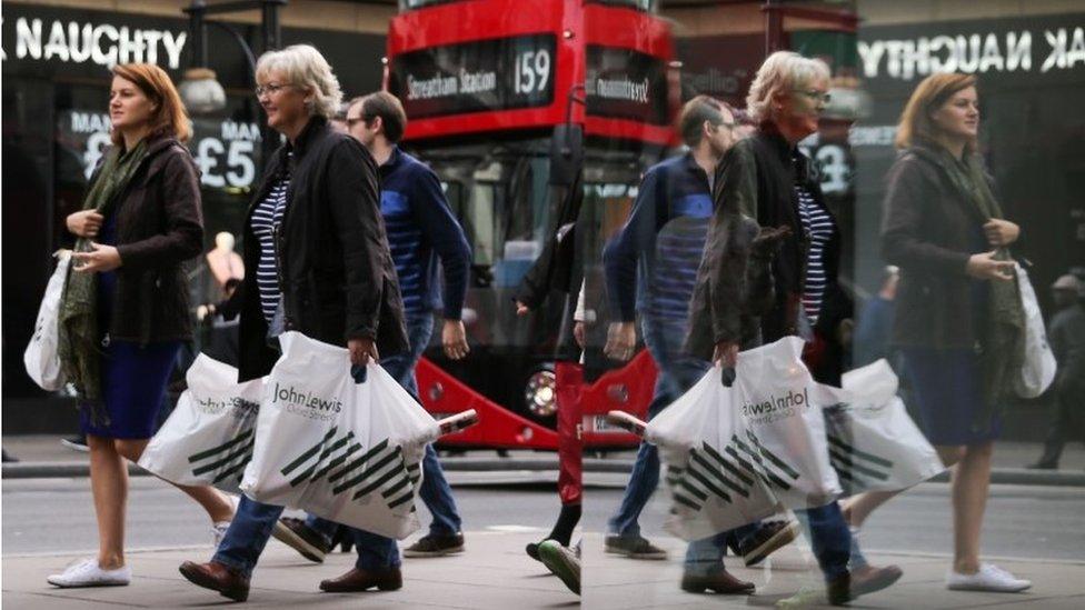 Shoppers reflected in window