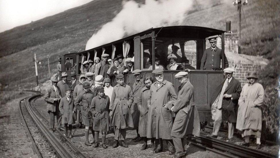 school's party in front of a train on the mountain