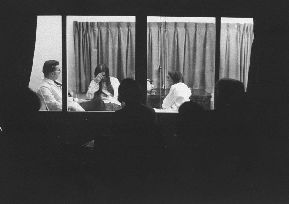 Elisabeth Kübler-Ross interviewing a woman with leukaemia in Chicago in 1969, with seminar participants behind a one-way mirror