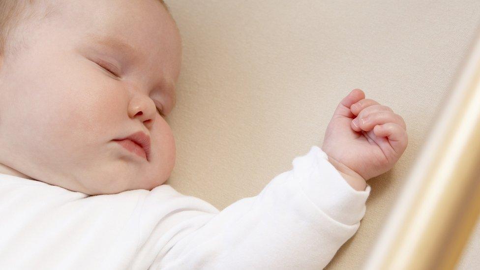 Baby sleeping in cot