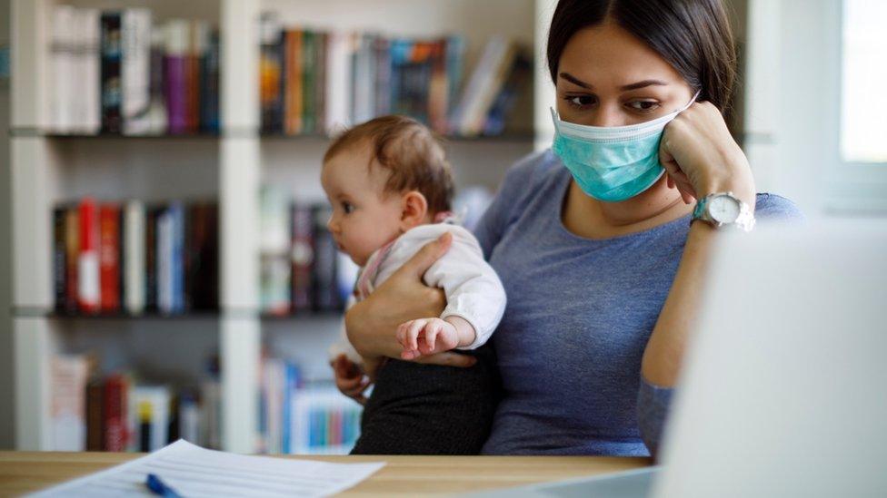 Woman with baby looks at computer