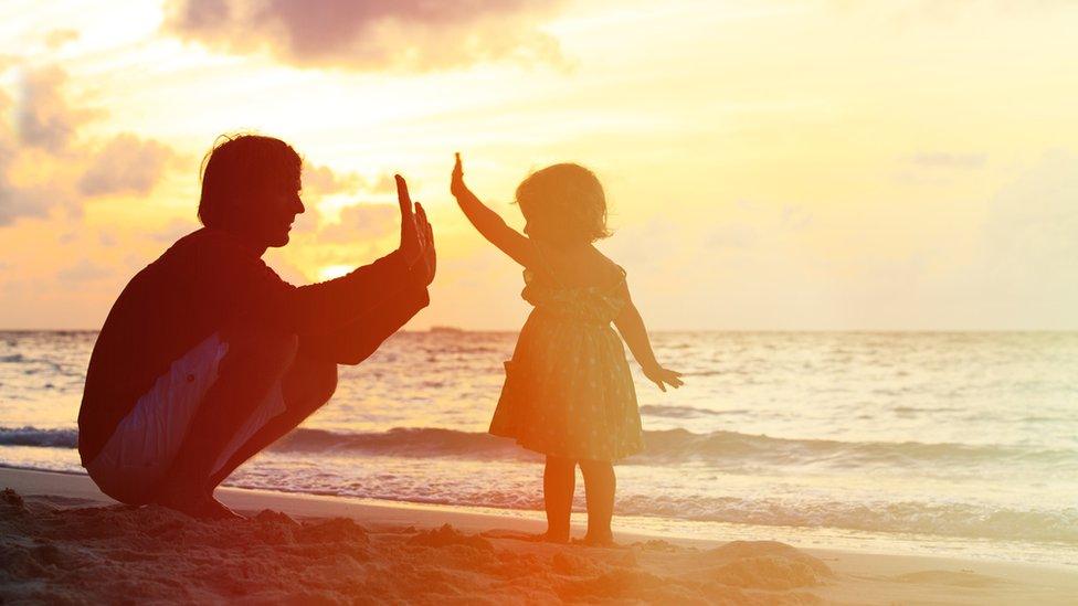 Father and child playing on a beach