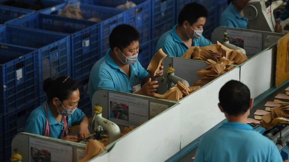 This file photo taken on September 14, 2016 shows workers on a production line at the Huajian shoe factory in Dongguan, southern China's Guangdong province.