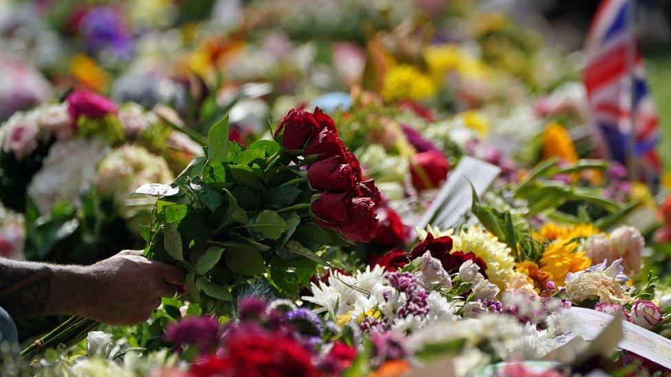 Members of the public laying floral tributes in Green Park, near Buckingham Palace, London. Queen Elizabeth II's coffin is travelling from Balmoral to Edinburgh, where it will lie at rest at the Palace of Holyroodhouse. Picture date: Sunday September 11, 2022