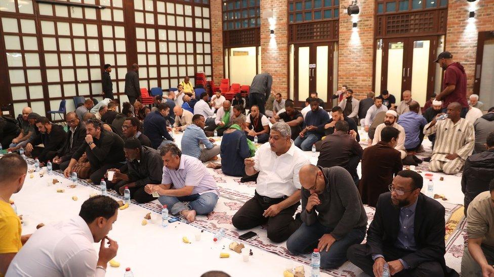 People sharing food at the Al Manaar Mosque in 2017