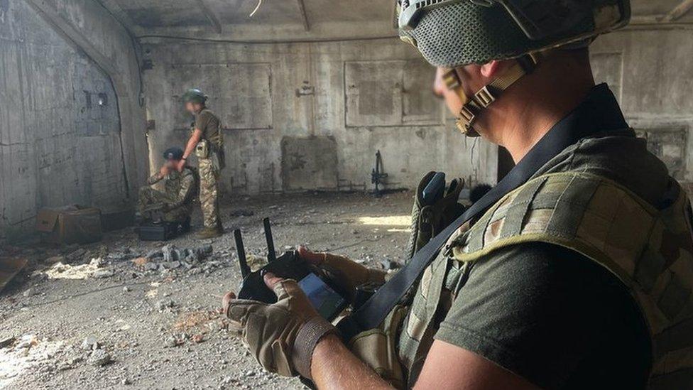 Pilot controlling and monitoring drone from inside a hangar