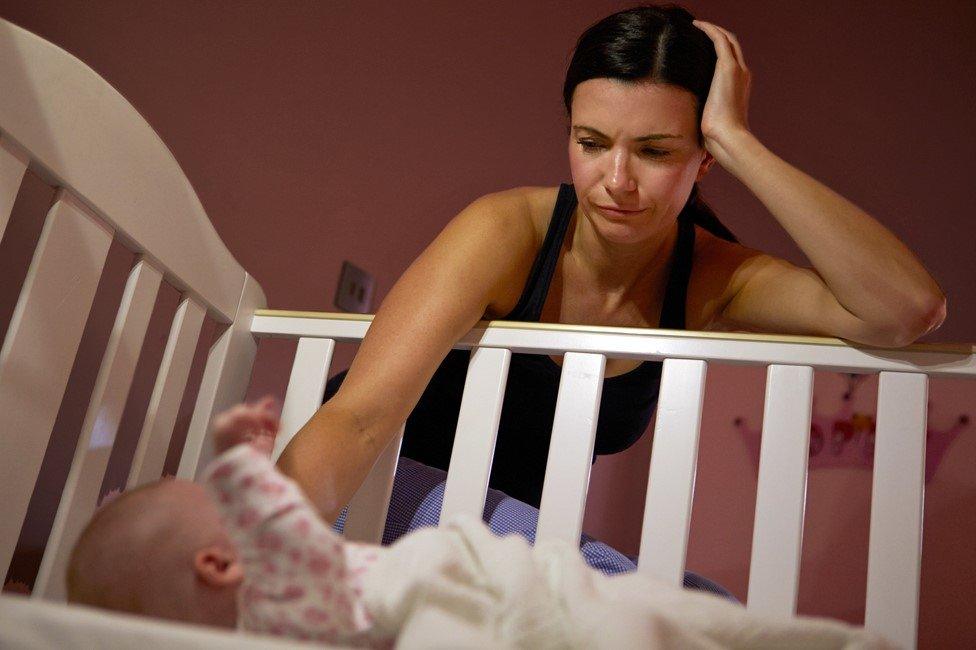 A tired mum tries to get her baby off to sleep