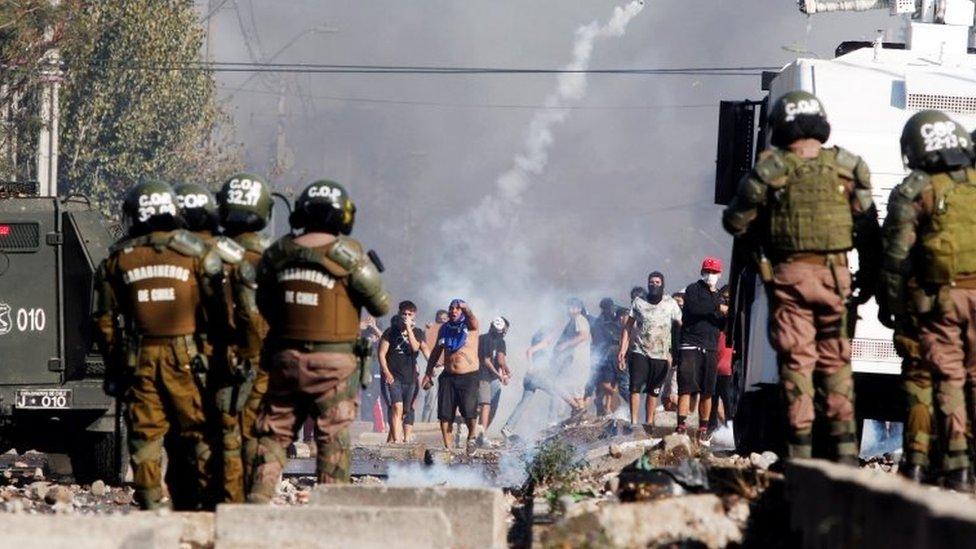 People clash with police during a protest for lack of food