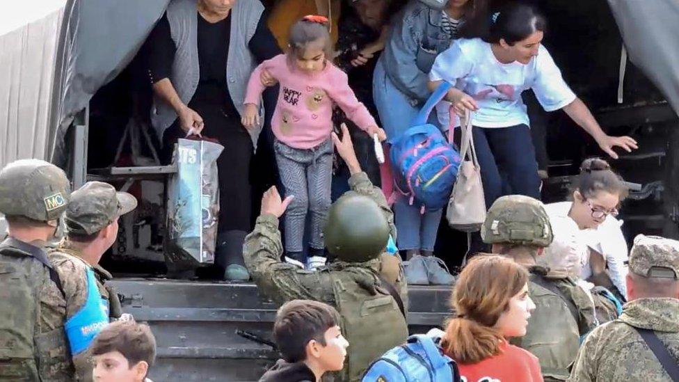 A still image taken from a handout video provided by the Russian Defence Ministry press-service shows Russian peacekeepers evacuating civilians at an undisclosed location in Nagorno-Karabakh, 20 September 2023.