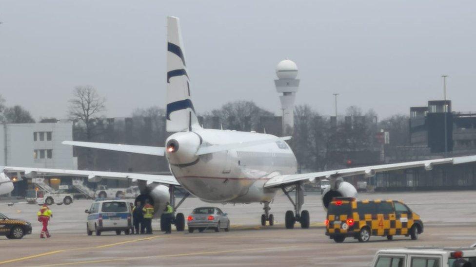 Photograph shows security vehicles near to aircraft