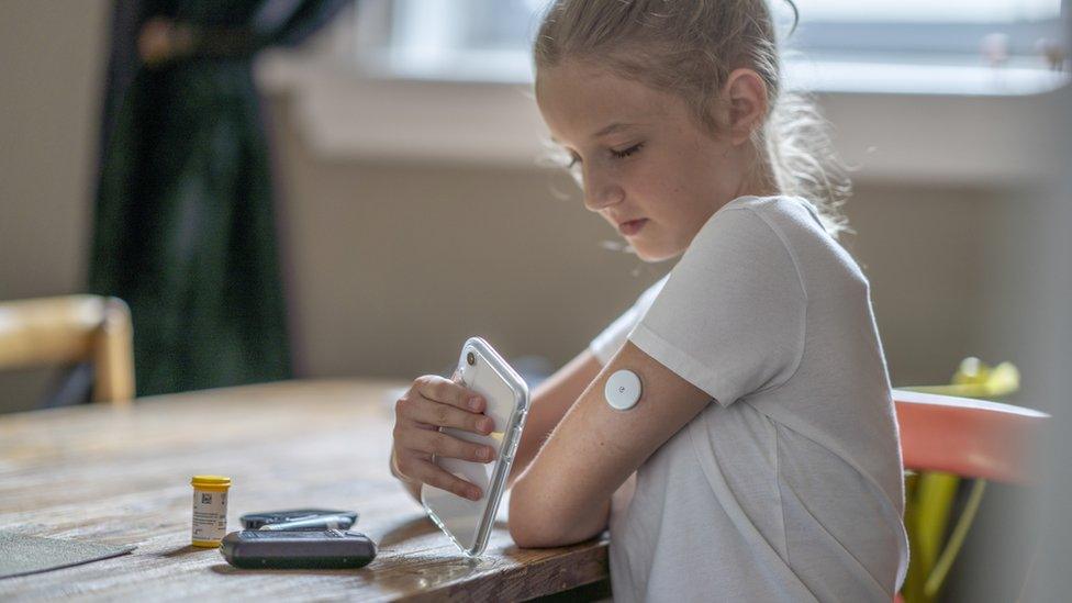 child with a diabetes smartphone monitor