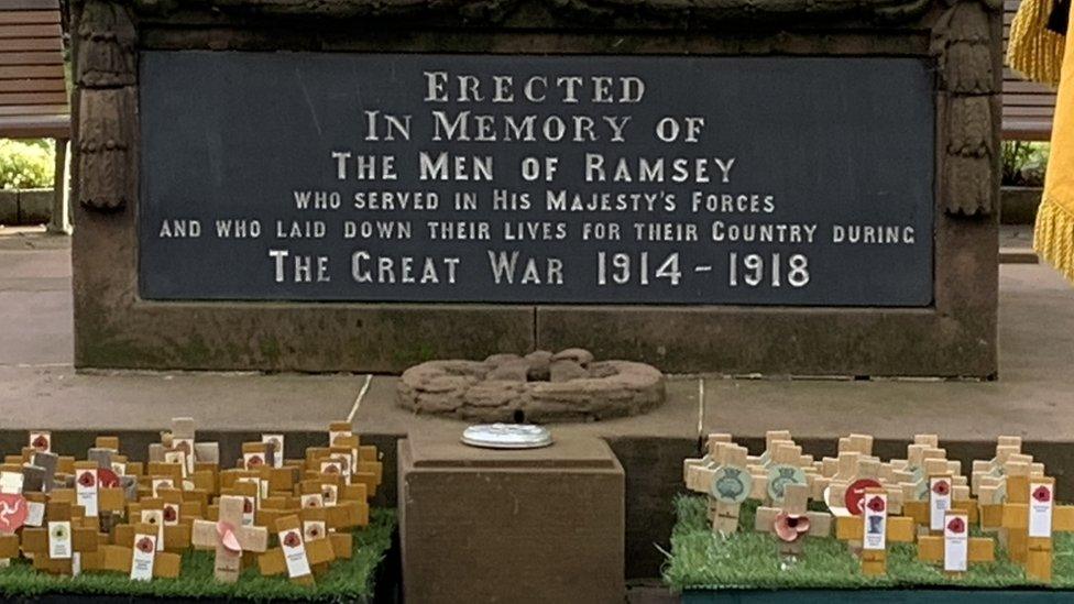 Wooden crosses in front of war memorial