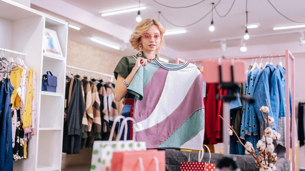 A fashion blogger holding up a t-shirt