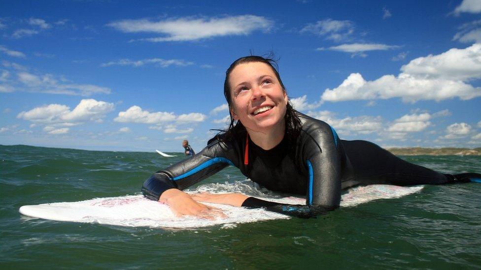 A woman surfing in Llangennith, Gower