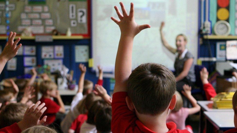 Children at school raising their hands