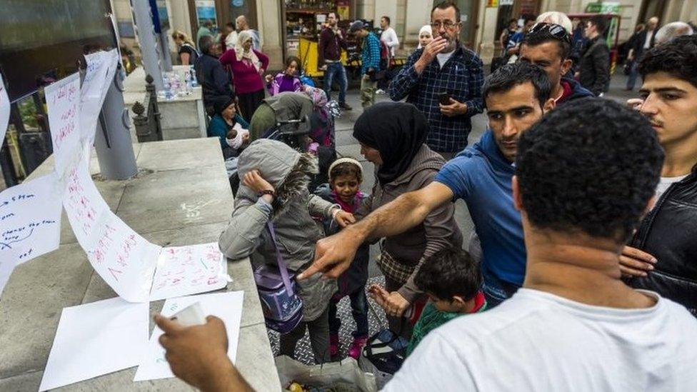 Migrants read handwritten Arabic notes at Keleti railway station in Budapest (05 September 2015)