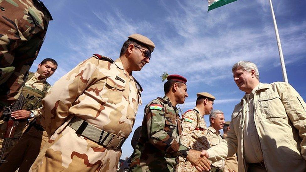 Canadian Prime Minister Stephen Harper (R) greets Iraqi Kurdish Peshmerga forces during a visit on the front line in Khazer near the Kurdish checkpoint of Aski kalak, 40 km West of Arbil, the capital of the autonomous Kurdish region of northern Iraq on May 2, 2015