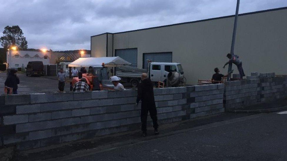 Local residents building a wall at the entrance of a disused hotel in Séméac. Photo: 24 July 2017