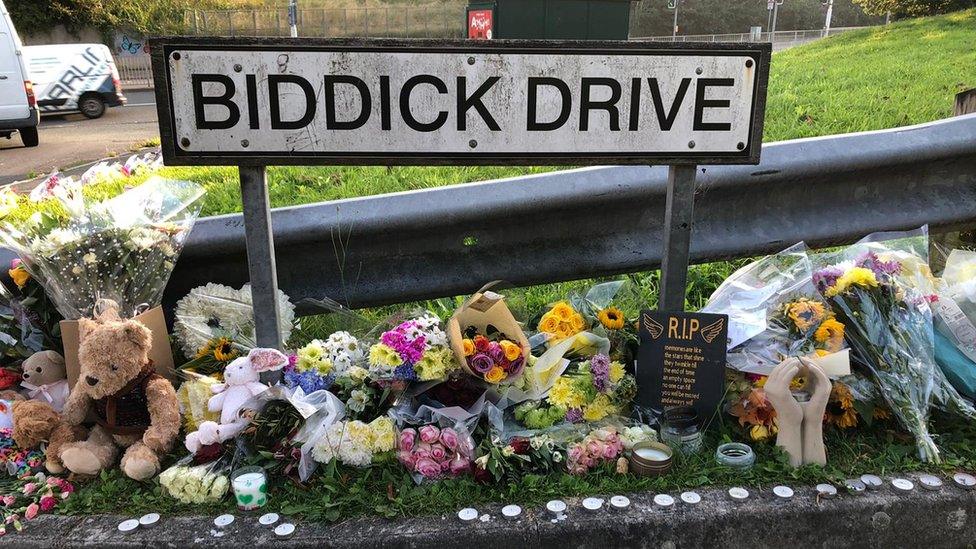 Flowers lie next to Biddick Drive sign