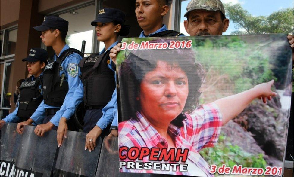 A man holds a poster during a protest demanding justice in the murder of Berta Caceres