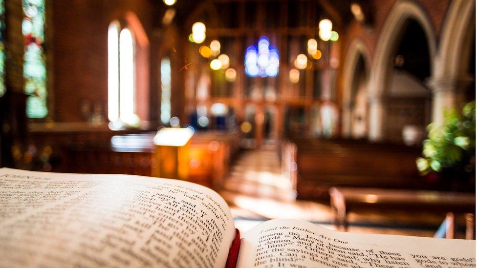 An open Bible looking out into a church.