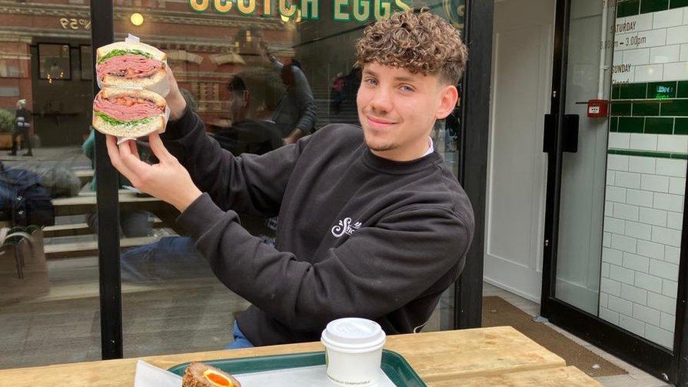 A man holding up a huge sandwich