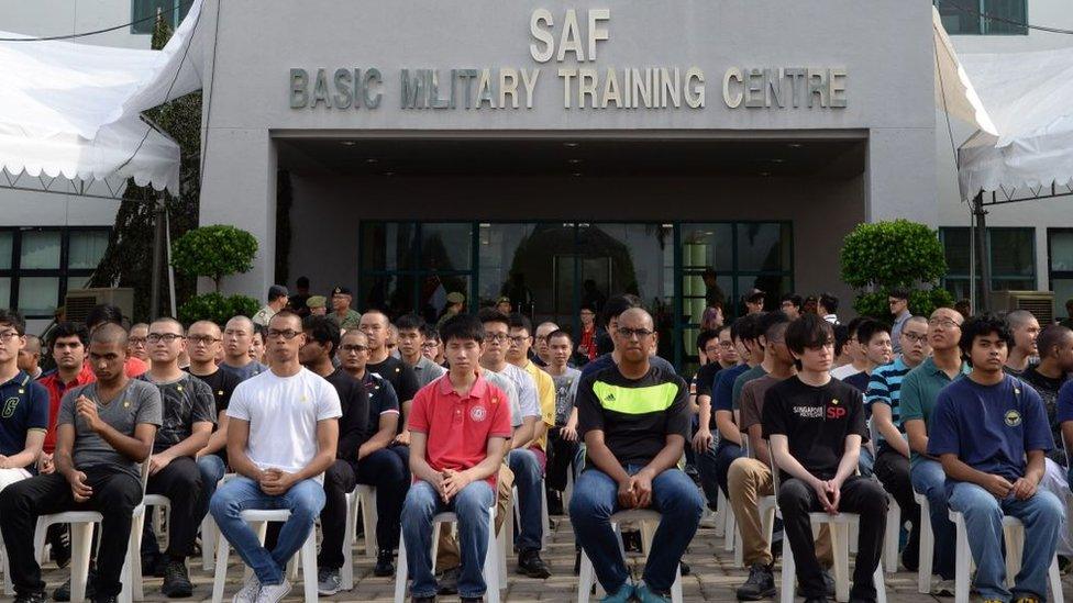 Incoming National Service recruits wait to take an oath