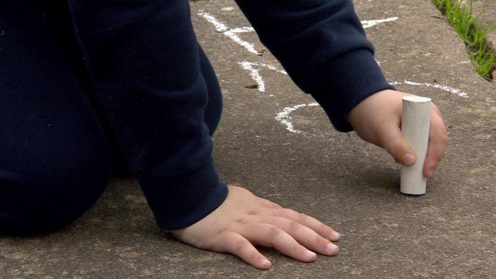 child drawing with chalk