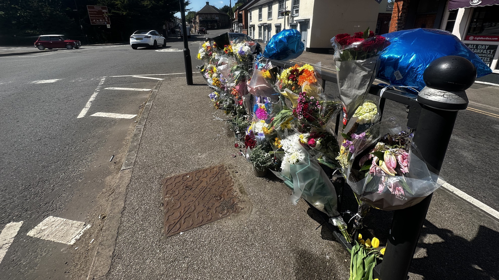 Flowers and a photo of Lucas Pollard left by railings