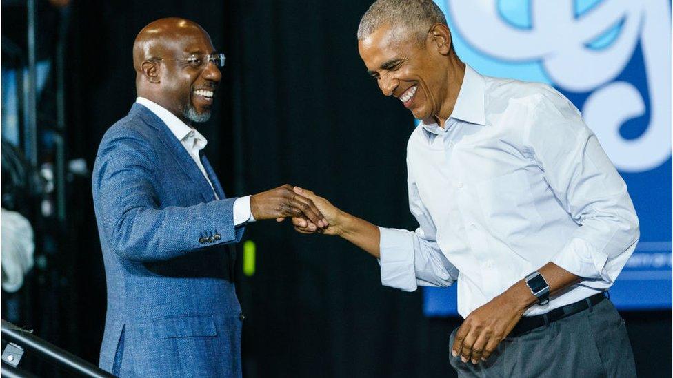 Obama and Warnock shaking hands