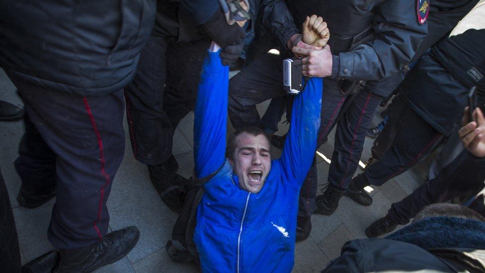 Police detain a protester in Moscow, Sunday, March 26, 2017.