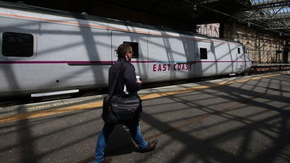 Man on platform in front of East Coast train